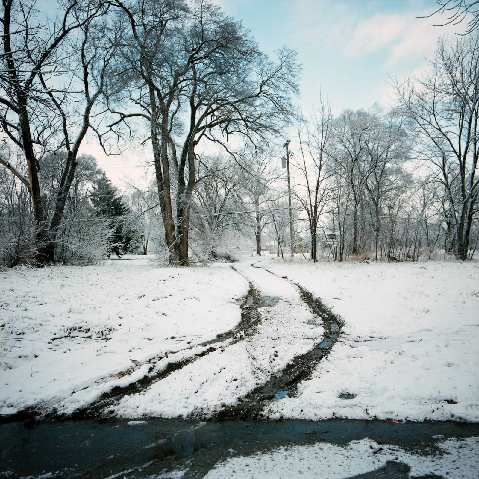 Tire tracks in snow, in abandoned neighborhood in Detroit.